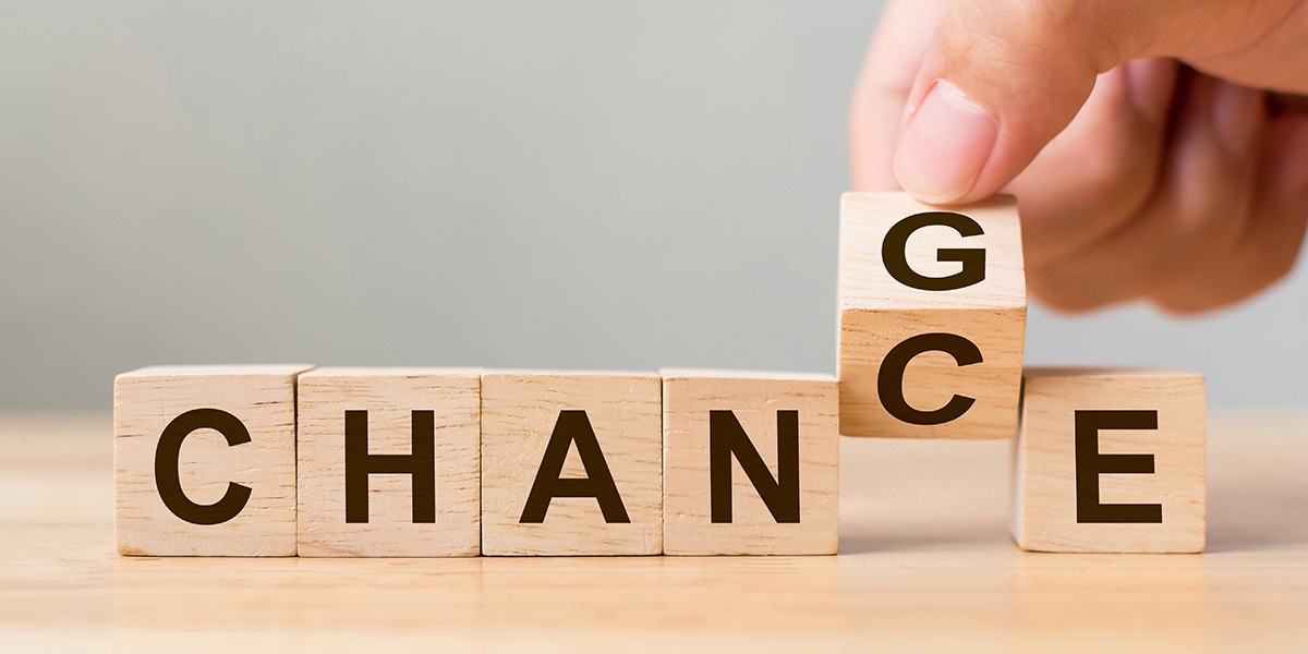 start_karriere_schwanteland Hand legt einen Holzbaustein mit dem Buchstaben 'G' an eine Reihe von Holzbausteinen, die das Wort 'CHANCE' bilden.